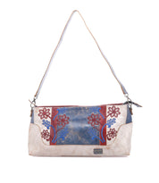 The Bed Stu Hyperbolic is a handcrafted beige leather shoulder bag with a long strap, blue and red floral embroidery on the front, and bohemian blue and brown accents.
