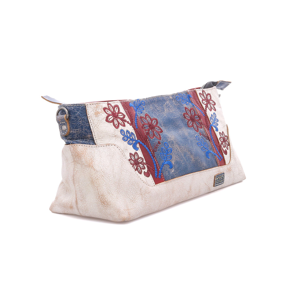 The Bed Stu Hyperbolic is a beige handcrafted leather shoulder bag featuring blue and red floral embroidery, blue accents, and a top metal zipper, shown against a white background.