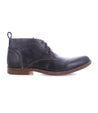 A single dark blue Illiad chukka boot from Bed Stu shown against a white background, featuring lace-up closure and a small heel.