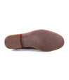 Sole of a brown leather chukka boot with textured grip and Bed Stu imprint visible, isolated on a white background.