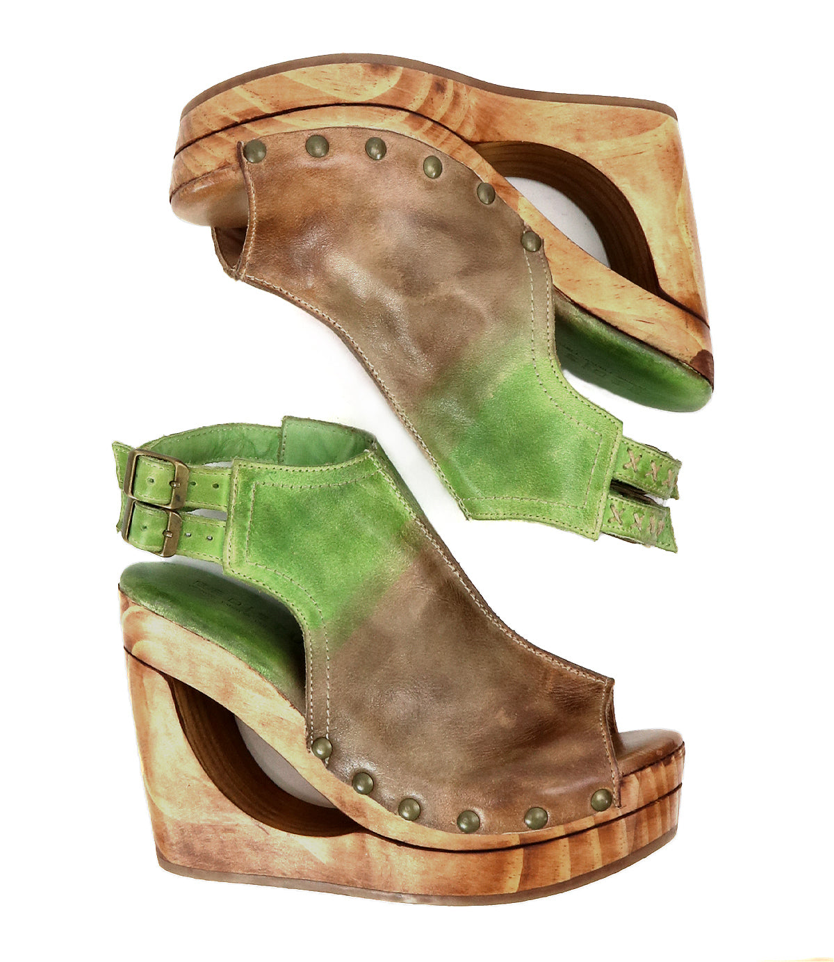 The Imelda by Bed Stu are brown and green wedge sandals with metal studs, wooden platforms, and distinctive cutout details in an open-toe design.