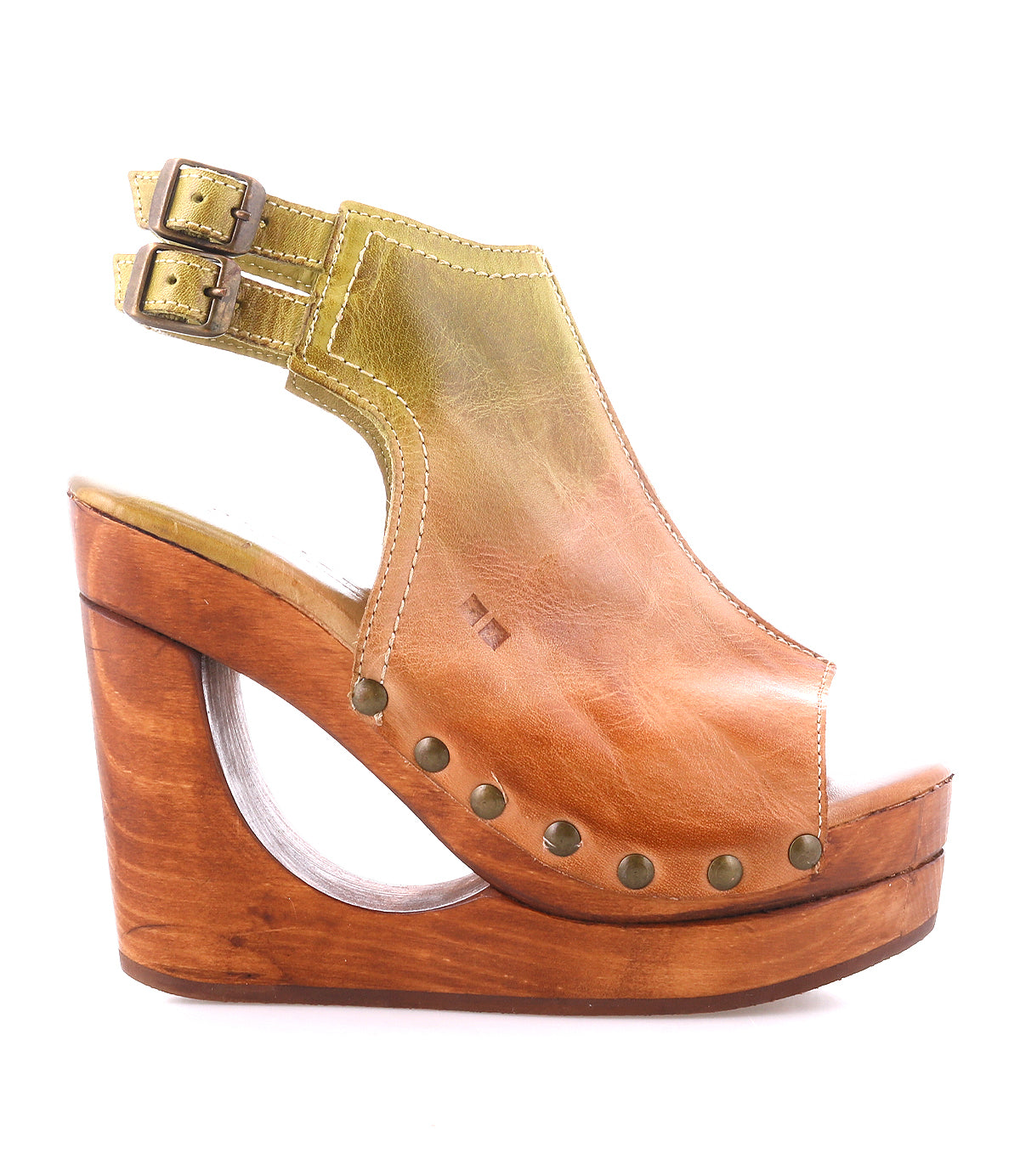 The Imelda by Bed Stu is a brown leather platform wedge sandal featuring metal studs, double ankle buckles, an open toe, and a wooden heel with a cut-out section.