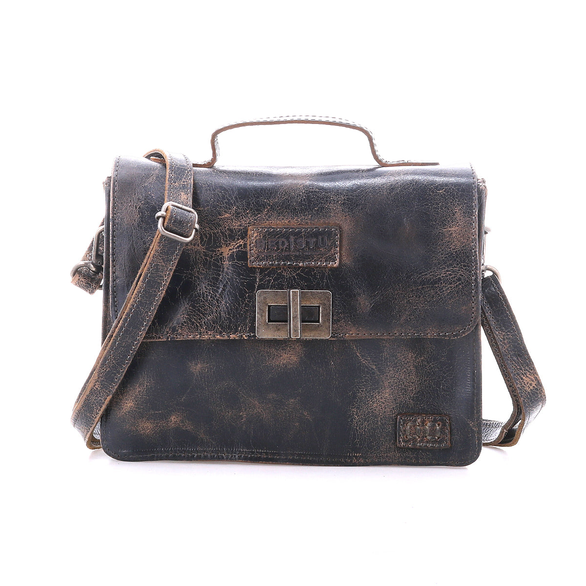 The Bed Stu Improv is a worn brown leather satchel with a front flap, metal buckle closure, top handle, and adjustable crossbody strap, blending style and function against a plain white background.