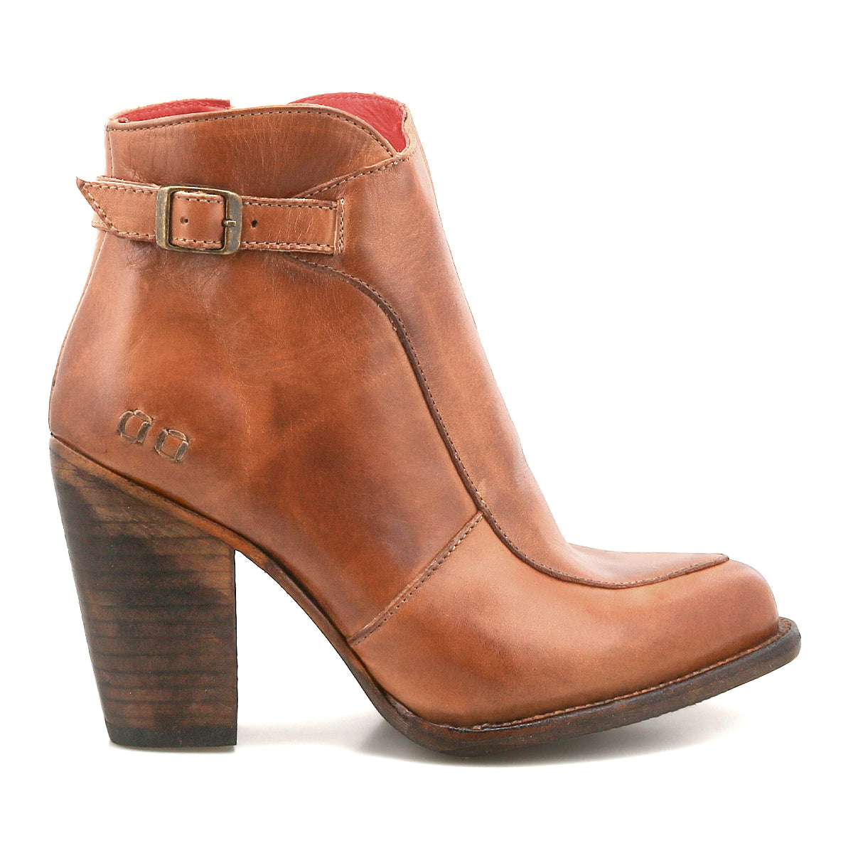 The Isla by Bed Stu is a brown leather bootie featuring a medium-high stacked heel, vintage buckle detail, and delicate stitched accents for a timeless style.