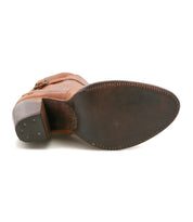 Bottom view of the Bed Stu Isla brown leather heeled bootie, featuring a pointed toe, visible stitching, a stacked heel, and metal tacks on the heel.