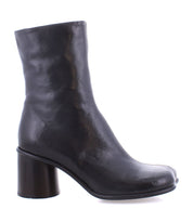 The Isodora by Bed Stu is a black leather ankle boot featuring an asymmetrical square toe and a thick, rounded heel, handcrafted for a unique style.