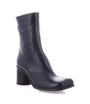 The Isodora by Bed Stu is a black leather ankle boot, handcrafted from Italian leather, showcasing a high block heel and rounded toe with a smooth finish, displayed on a white background.