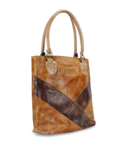 The Bed Stu Italic is a brown leather tote bag with dual handles, featuring a timeless design and a diagonal dark brown stripe across the front. Its spacious interior makes it as practical as it is stylish.