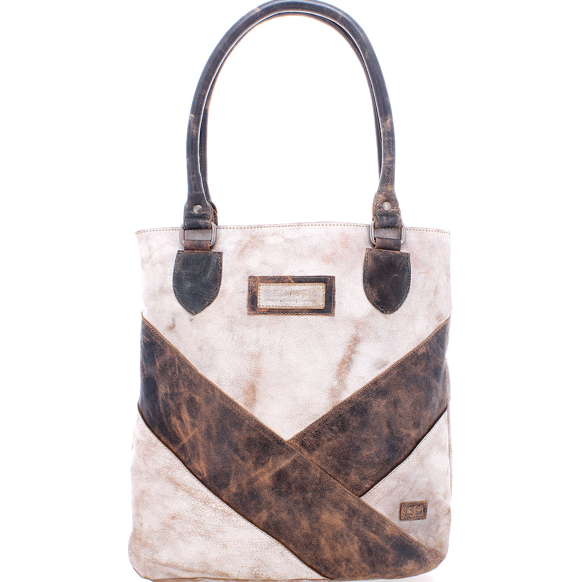 The Italic tote bag by Bed Stu is beige and brown leather with dark handles, a spacious interior, crisscross design, and features a rectangular label on the front.