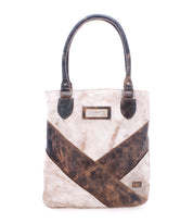 The Italic tote bag by Bed Stu is beige and brown leather with dark handles, a spacious interior, crisscross design, and features a rectangular label on the front.