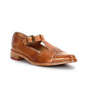 The Bed Stu Jenny is a brown leather Mary Jane casual shoe with a T-strap pointed toe, buckle strap, low wooden heel, cushioned insole, and decorative stitching, shown on a white background.
