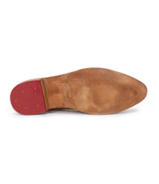 The image features the sole of Bed Stu's Jenny brown leather dress shoe, showcasing a red heel, visible stitching, and wear marks that blend classic style with the cushioned insole comfort of modern casual footwear.