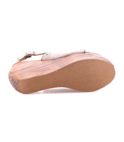 A close-up view of the Joann II sandal by Bed Stu showcases its sustainable wooden wedge platform and textured rubber sole, set against a white background.