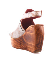 Back view of the Bed Stu Joann II, a high-heeled wooden wedge platform with a light brown upper, metal studs, and ankle strap—blending elegance with sustainable style.