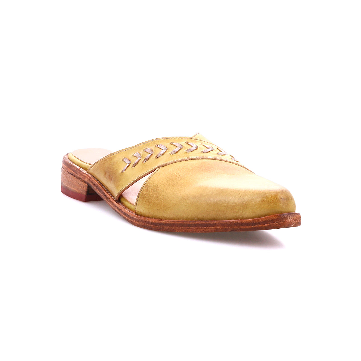 The Bed Stu Jockey is a yellow leather slip-on shoe featuring a pointed toe, low wooden heel, and decorative stitching on the upper, displayed against a white background.