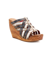 The Josie II wedge sandal by Bed Stu features crisscrossed denim and metallic straps, accented with metal studs and rivet details on a wooden sole for a bold, modern look.