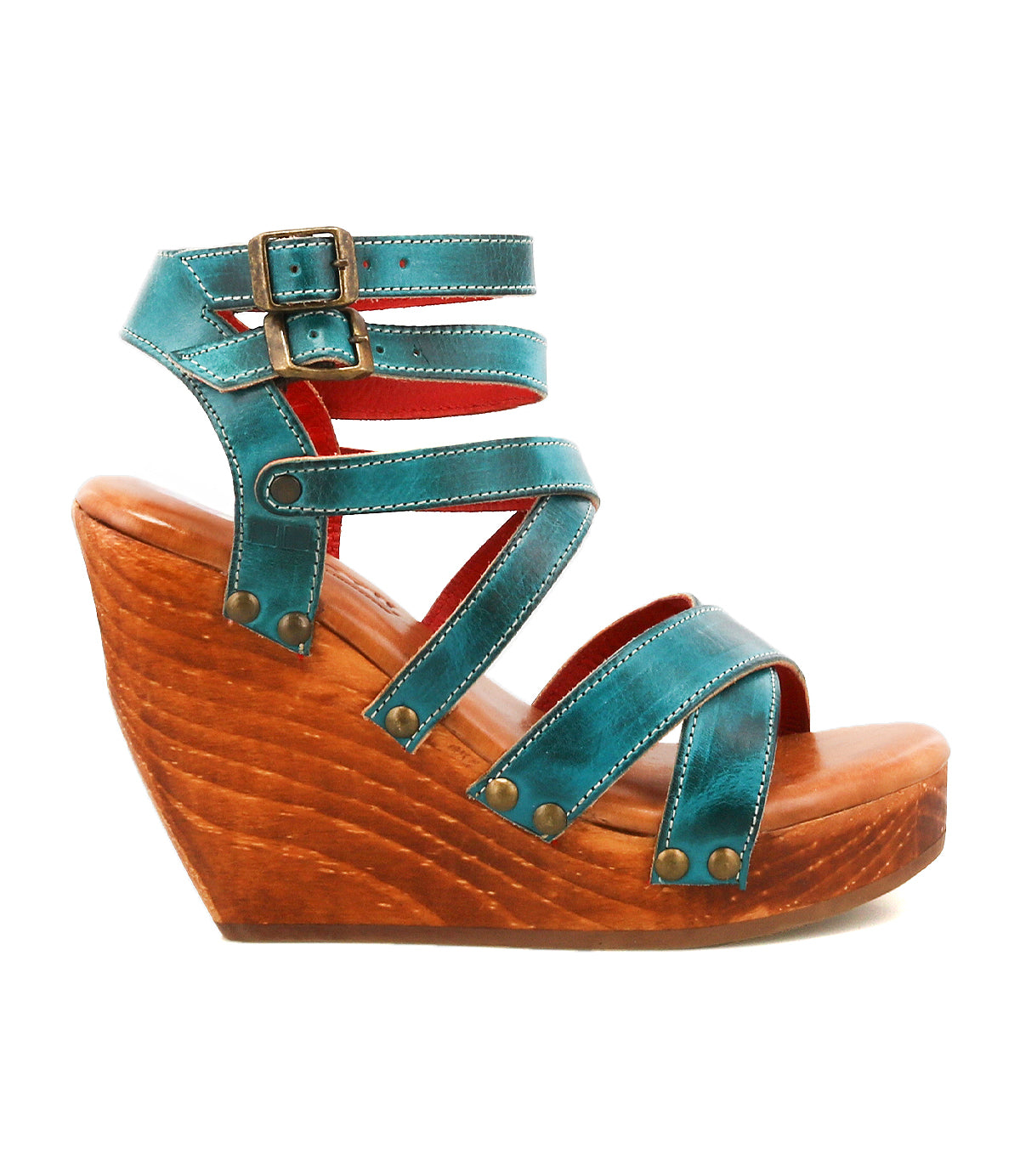The Bed Stu Juliana II wedge sandal features a teal strappy upper, wooden platform sole, buckle closures, and metal rivet accents, displayed in a side view against a white background.