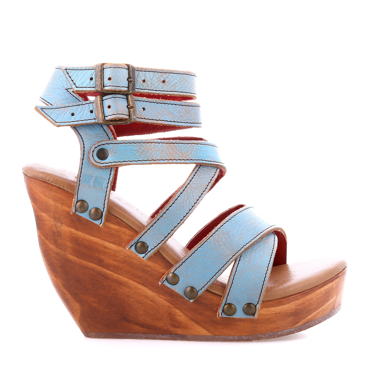 The Juliana II by Bed Stu is a light blue wedge sandal with multiple straps and buckle closures, cushioned comfy wedge, and a wooden platform heel.