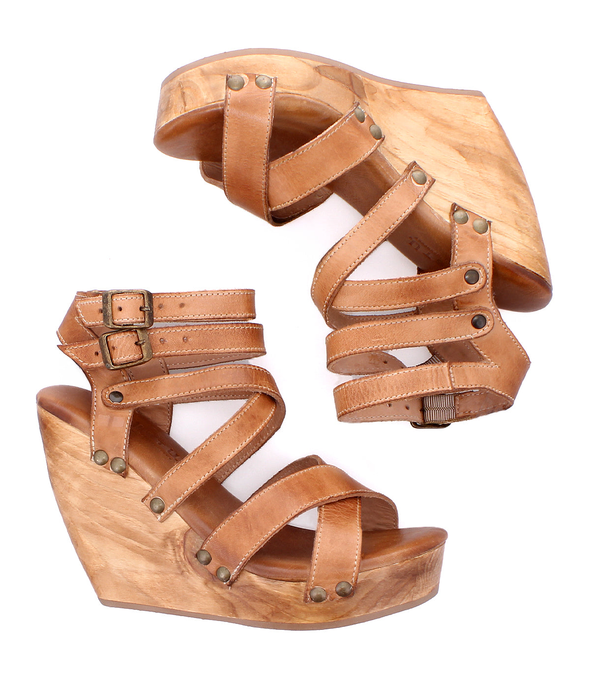The Juliana II by Bed Stu are tan wedge sandals with strappy studded uppers, wooden platform soles, adjustable ankle straps, and decorative metal studs.
