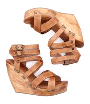 The Juliana II by Bed Stu are tan wedge sandals with strappy studded uppers, wooden platform soles, adjustable ankle straps, and decorative metal studs.