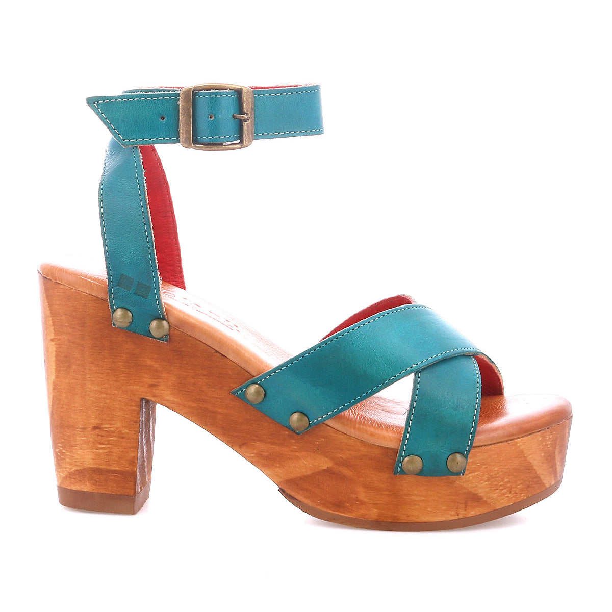 The Bed Stu Kalah is a teal leather platform sandal with a sustainably sourced wooden block heel, ankle strap, bronze buckle, crisscross toe design, and decorative metal studs.