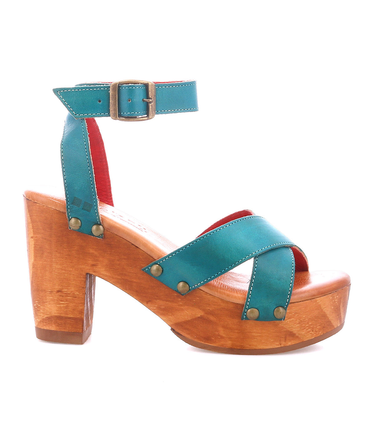 The Bed Stu Kalah is a teal leather platform sandal with a sustainably sourced wooden block heel, ankle strap, bronze buckle, crisscross toe design, and decorative metal studs.