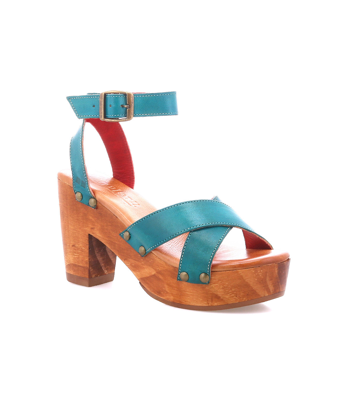 The Bed Stu Kalah is a teal leather sandal with an ankle strap, buckle, crisscross toe design with metal rivets, and a sustainably sourced wooden platform heel, shown against a white background.