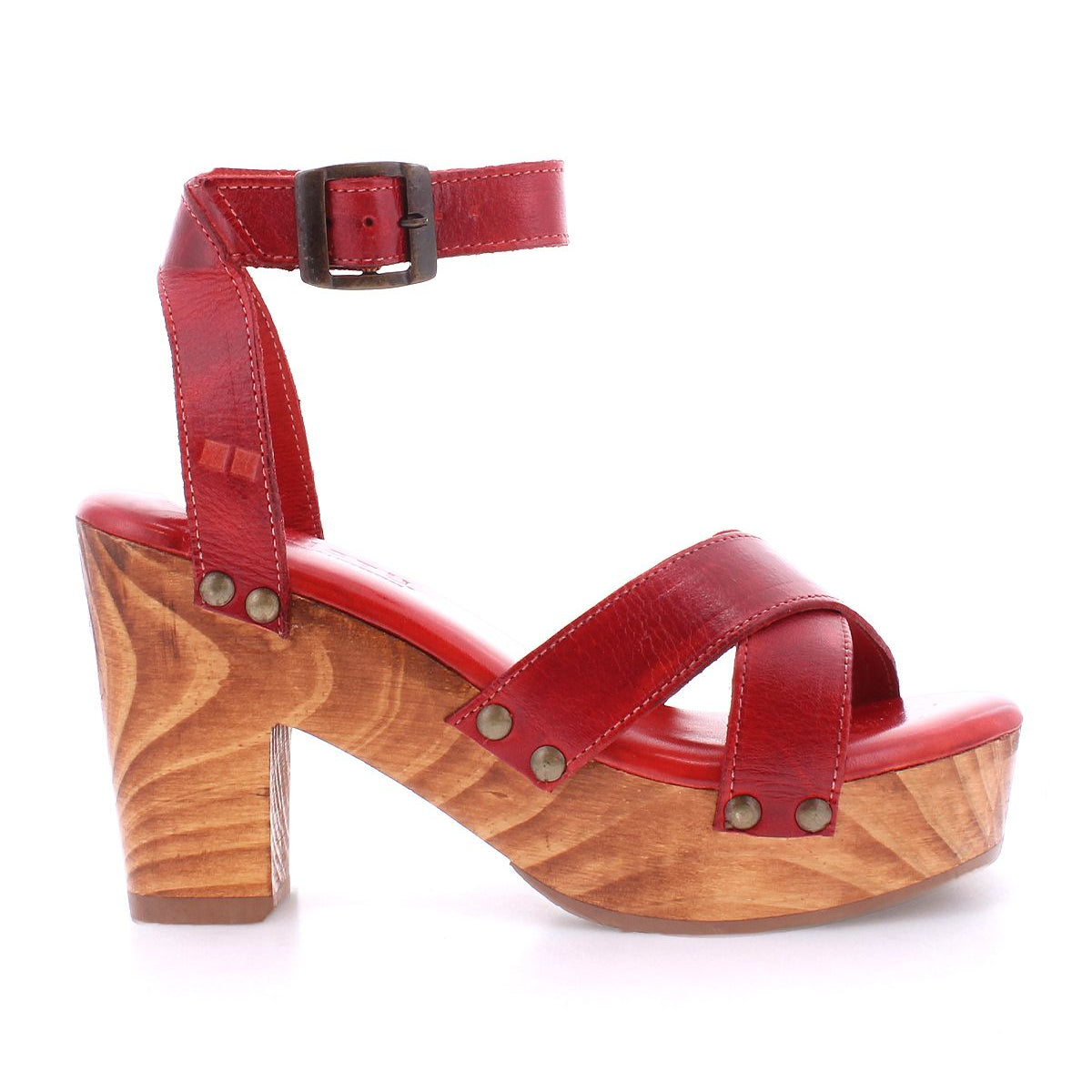 The Kalah by Bed Stu is a red leather high-heeled sandal featuring a wooden sole, an ankle strap, metallic studs, and a stylish platform heel.