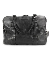 A handcrafted black leather travel duffle with two handles, an adjustable shoulder strap, and a zippered top closure. The Keg by Bed Stu features stitched detailing on the front.