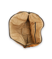 An open, empty, tan-colored handcrafted leather bag with a zippered inner pocket and beige fabric lining made from vegetable tanned leather called Keg by Bed Stu.
