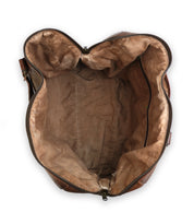 Top view of an empty, unzipped handcrafted brown leather travel duffle with a beige fabric interior, the Keg by Bed Stu.