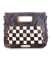 Bed Stu's Keiki handbag features a black and white checkered design, a cut-out handle, metal studs, a metallic brand plate at the bottom center, and an adjustable strap.