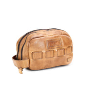 A brown leather dopp kit with a zipper closure and an attached handle, crafted from premium vegetable tanned leather—your perfect travel essential, the Kip by Bed Stu.