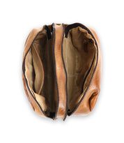 A tan leather Kip by Bed Stu with two zippered compartments, displayed open to reveal its beige fabric-lined interior—perfect for organizing travel essentials.