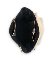 A photo of the inside of an open, empty canvas or fabric bag, showing a black lining and inner pockets crafted from vegetable tanned leather. The bag is the Kure by Bed Stu.