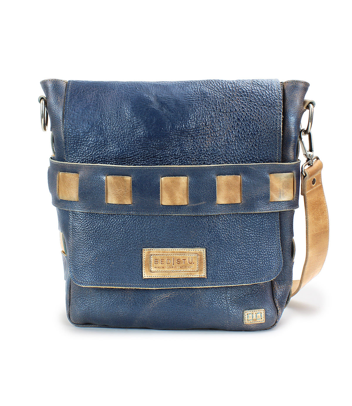 A blue leather crossbody bag with a tan strap and square tan accents on the front flap. The brand logo "Bed Stu" is displayed on a patch at the front. Crafted from vegetable tanned leather, this handmade Kure messenger bag boasts an organic cotton-lined interior.