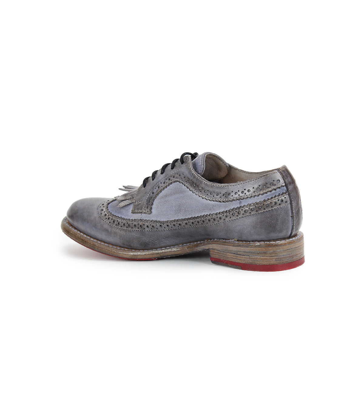 The Lita K by Bed Stu features a gray leather brogue design with a wingtip toe, lace-up closure, decorative perforations, and derby shape. It's finished with a wooden sole and chic red rubber heel.