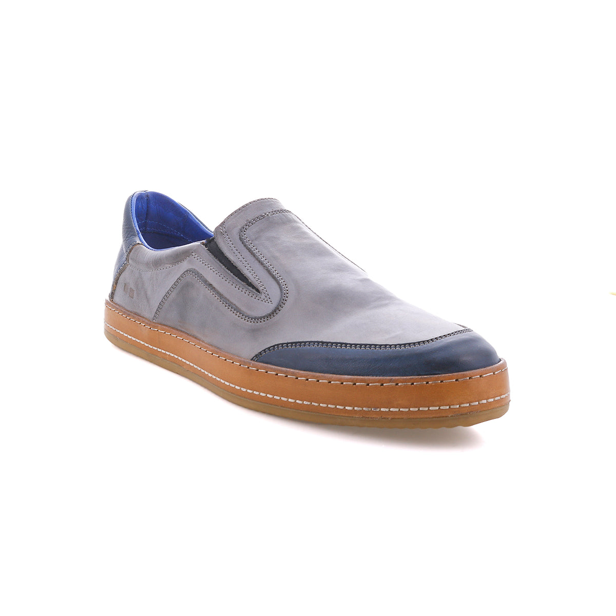 Introducing the Bed|Stü Lanius: a gray slip-on shoe featuring a tan sole and vibrant blue accents on the toe and inner lining. Displayed against a crisp white background, this style uses bold color blocking to give a contemporary update to a classic silhouette.