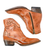 Pair of brown leather Laredoa ankle boots by Bed|Stü, inspired by feminine cowboy boots and featuring side zippers, decorative stitching, and low stacked heels, displayed on a white background.