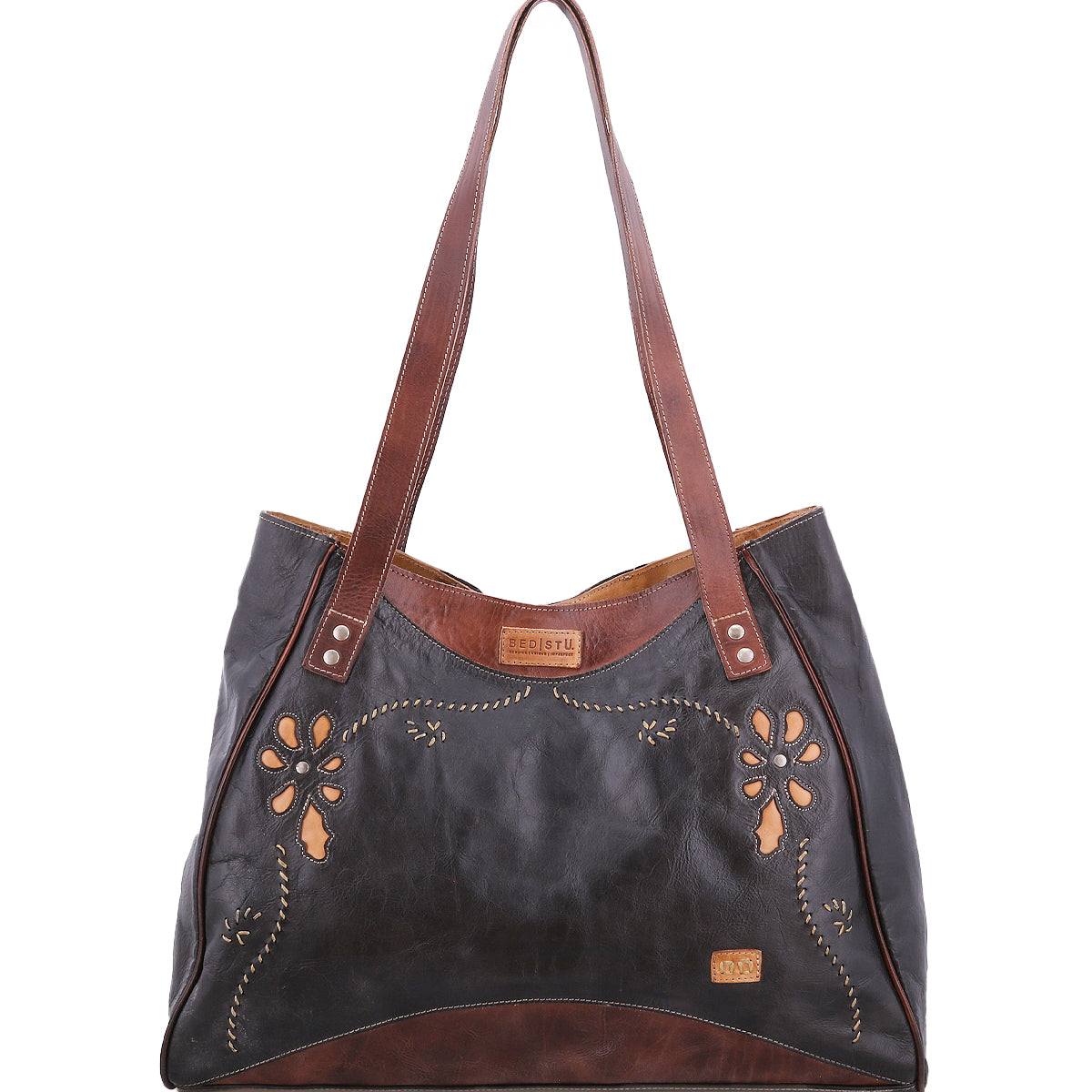 Black and brown leather tote bag with floral cutouts and decorative stitching.