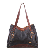 Black and brown leather tote bag with floral cutouts and decorative stitching.