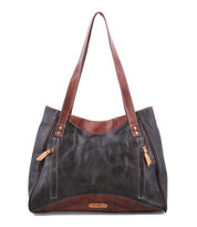 The Bed|Stü Larue LTC is a large black and brown leather shoulder bag with double shoulder straps, two front zippered pockets, and handstitched details, shown here on a white background.
