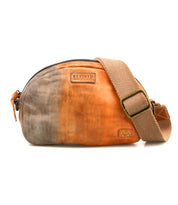 The Lavish by Bed Stu is a lightweight, two-tone leather crossbody bag with an adjustable fabric strap, zipper closure, and front logo patch—perfect for everyday use.