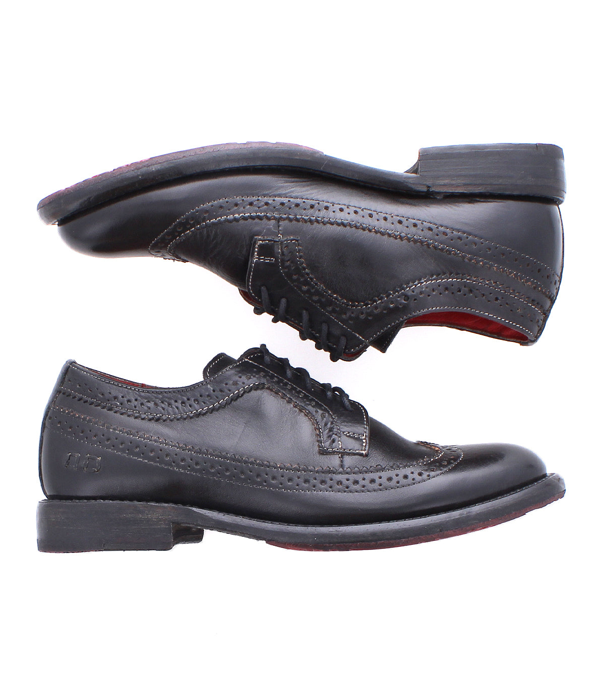 The Bed Stu Lita K II showcases two black leather wingtip shoes with brogue detailing and classic derby laces, displayed horizontally and opposite each other.