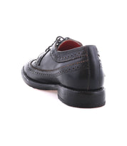 The Bed Stu Lita K II, a black leather wingtip derby shoe, is displayed from the back left angle on a white background.