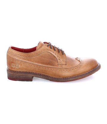 The Bed Stu Lita K II features a classic derby silhouette with brown leather, wingtip design, decorative perforations, and a bold red interior lining, offering a sophisticated look ideal for discerning footwear aficionados.