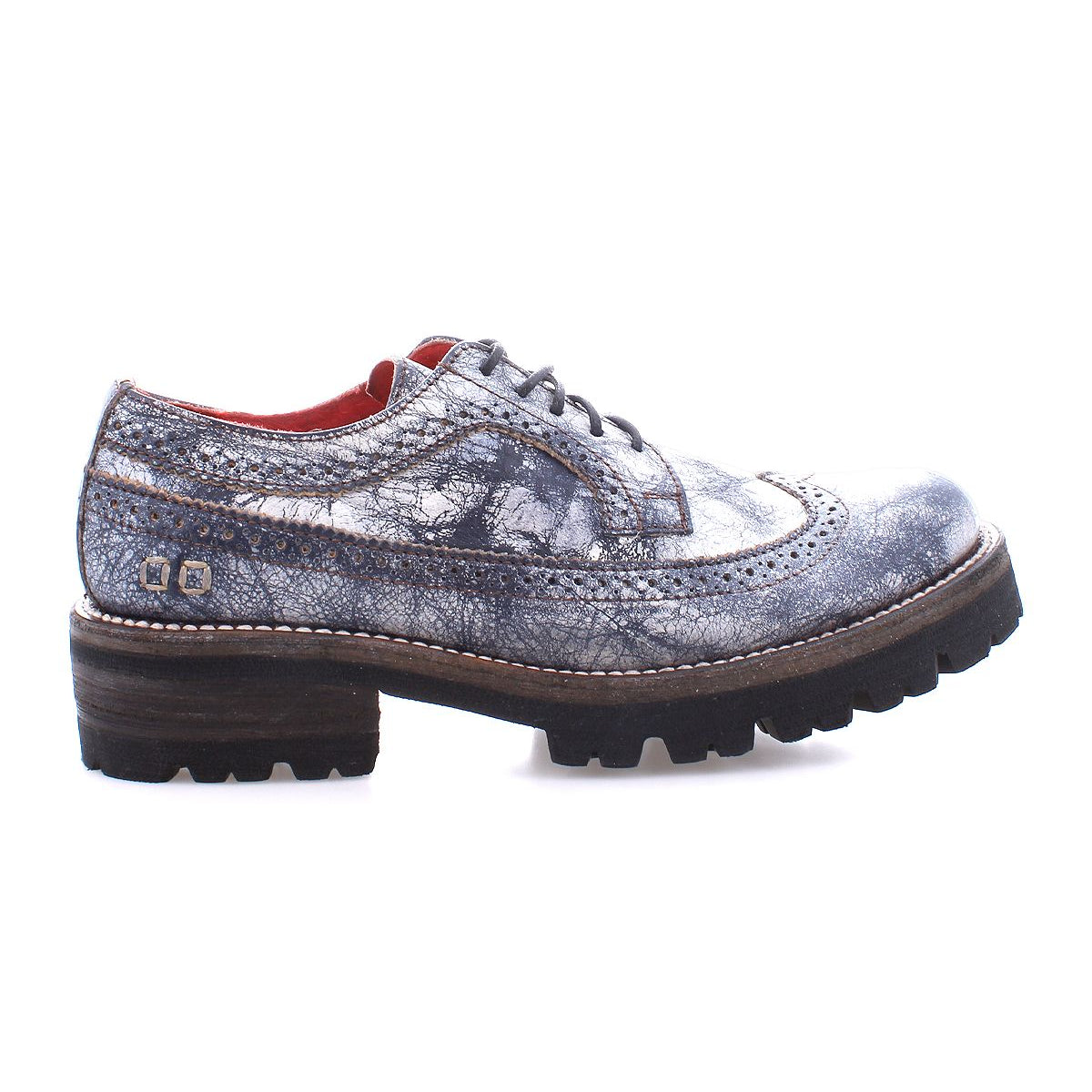The Lita K III by Bed Stu, a single gray and black brogue shoe featuring a rugged sole, side view, exudes retro chic sophistication while offering a nod to 90's fashion.