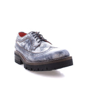 The Lita K III by Bed Stu, a gray leather Oxford shoe featuring a textured finish and thick black sole, is depicted from a low angle on a white background, embodying retro chic with a nod to 90’s fashion.
