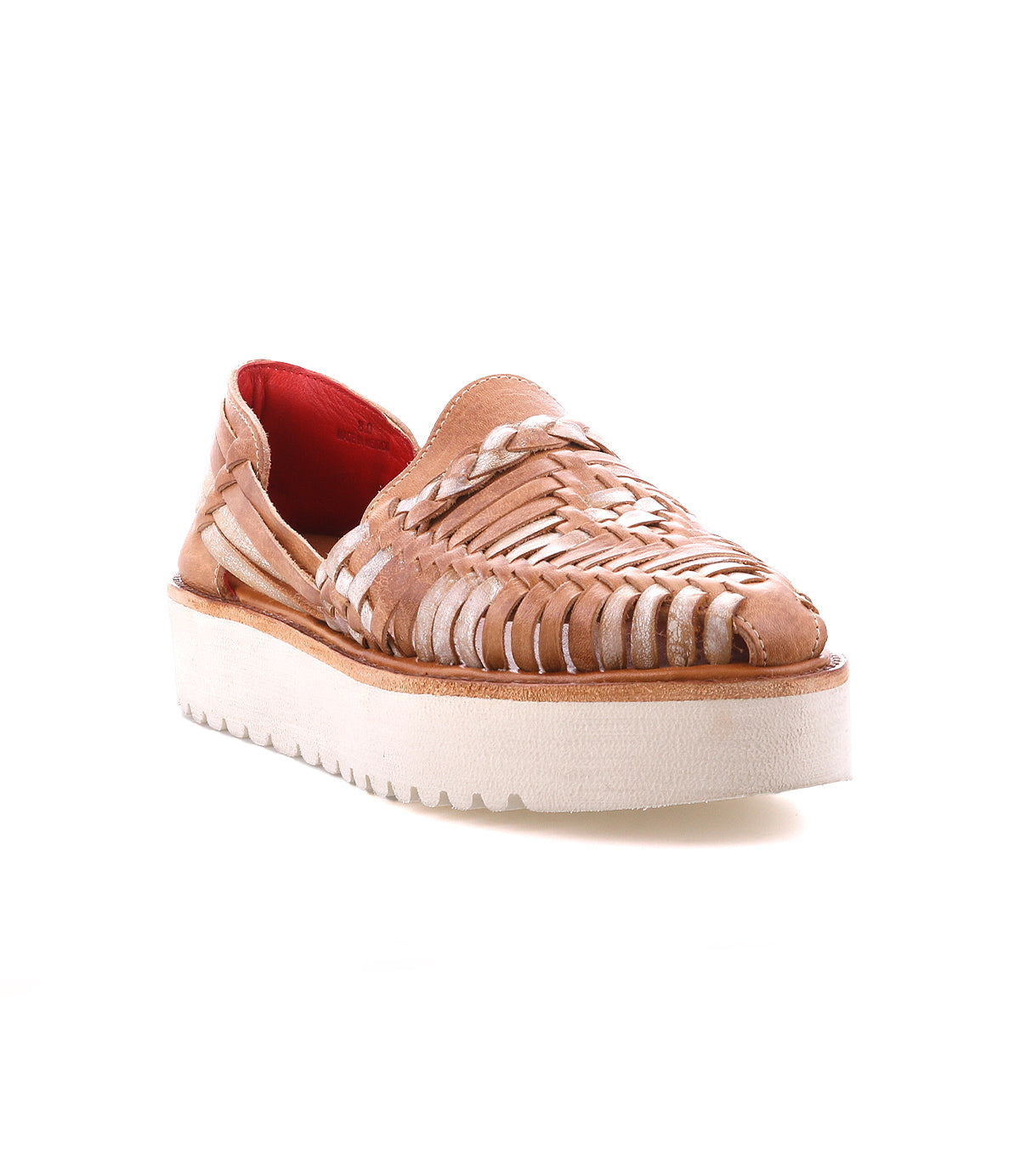 The Bed Stu Lizzie is a tan hand-woven leather slip-on featuring a white platform sole and red inner lining, shown on a white background.