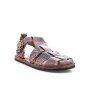 The Bed Stu Lone is a strappy sandal with distressed leather straps, an open toe, an antique brass side buckle, and a flat sole, shown against a white background.